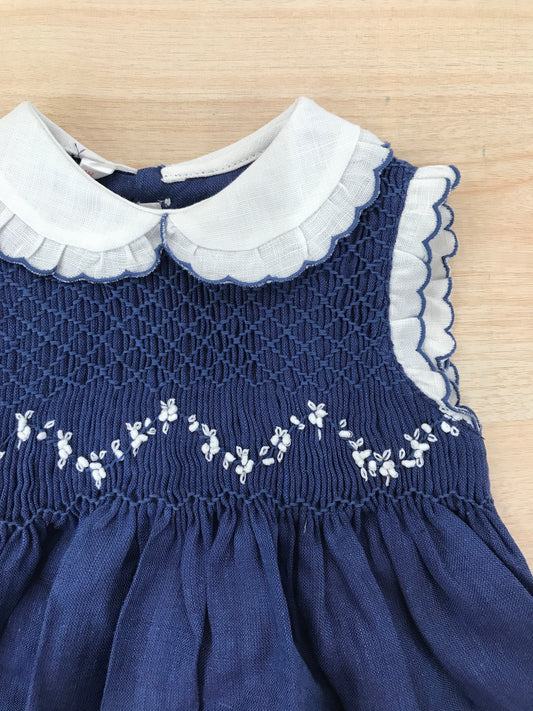 Abito Les Enfants de Gisele in lino smanicato con rusche bianche con colletto bianco e rusche rifinita in blu con corpetto lavorato da punto smock e fiorellini bianchi ricamati