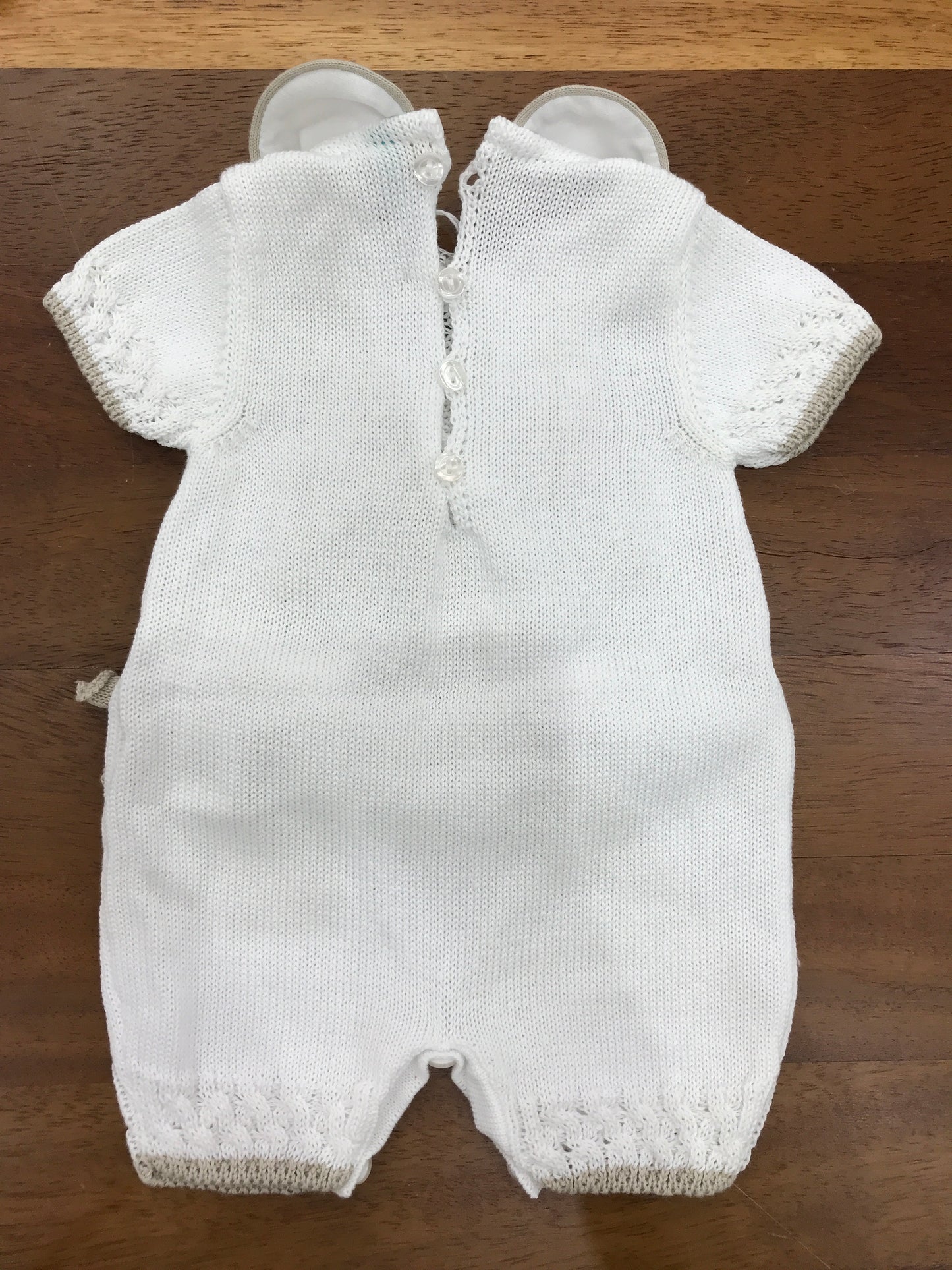 Pagliaccetto Bebè di Almy in filo bianco con fiocchi tortora al centro