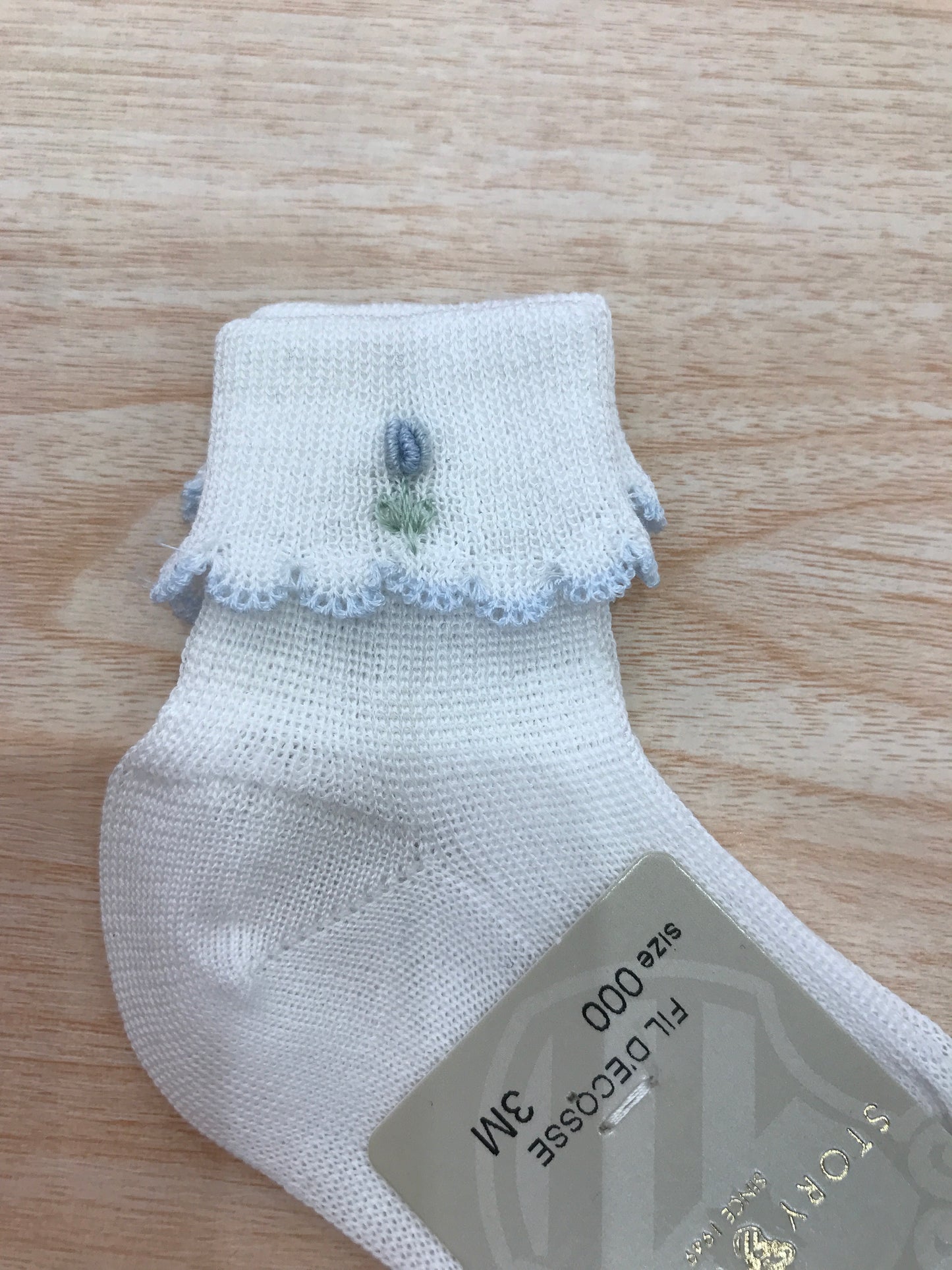 Calzino Story Loris in filo bianco con smerlo celeste con fiore celeste ricamato