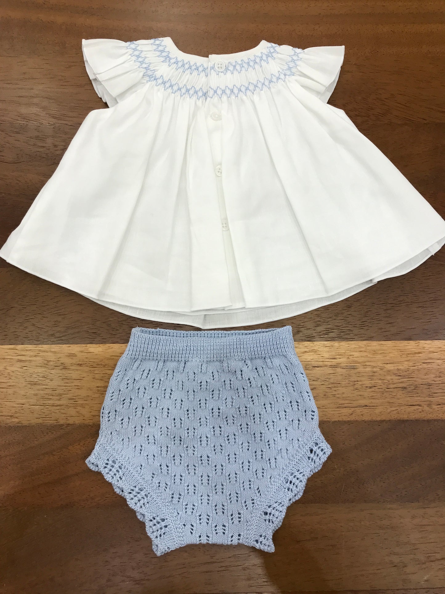 Pagliaccetto Paz Rodriguez in lino bianco con collo lavorato da punto smock in celeste con culotte abbinata in filo traforata