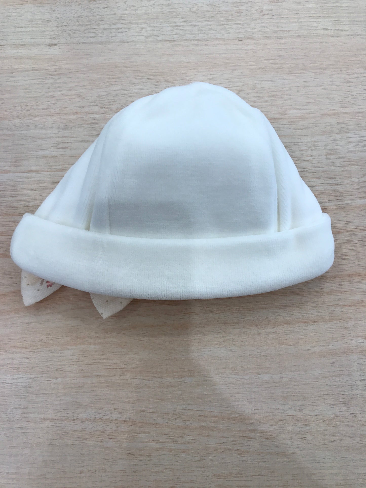 Cappello Baby Gi in ciniglia panna con risvolto e fiocchetto floreale