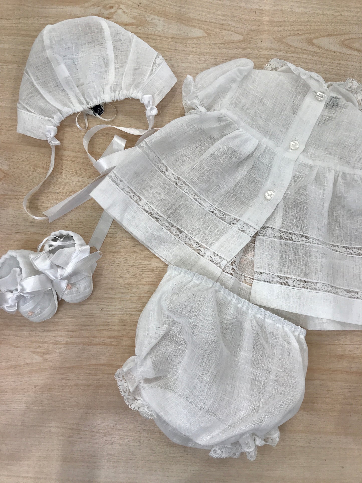 Coordinato Piccola Giuggiola in lino abitino con lavorazioni in pizzo e roselline ricamate con culotte cuffia e scarpine coordinate