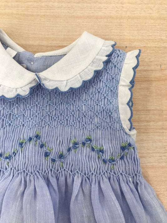 Abito Les Enfants de Gisele in lino smanicato con rusche bianche con colletto bianco e rusche rifinita in celeste con corpetto lavorato da punto smock e fiorellini bianchi ricamati