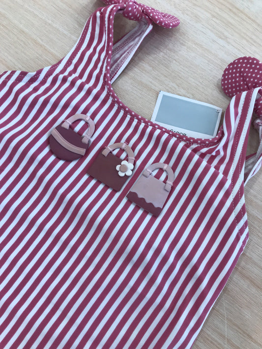 Costume Al Agua Patos intero a righe bianche e fucsia con bretelle con fiocchetto e rusche