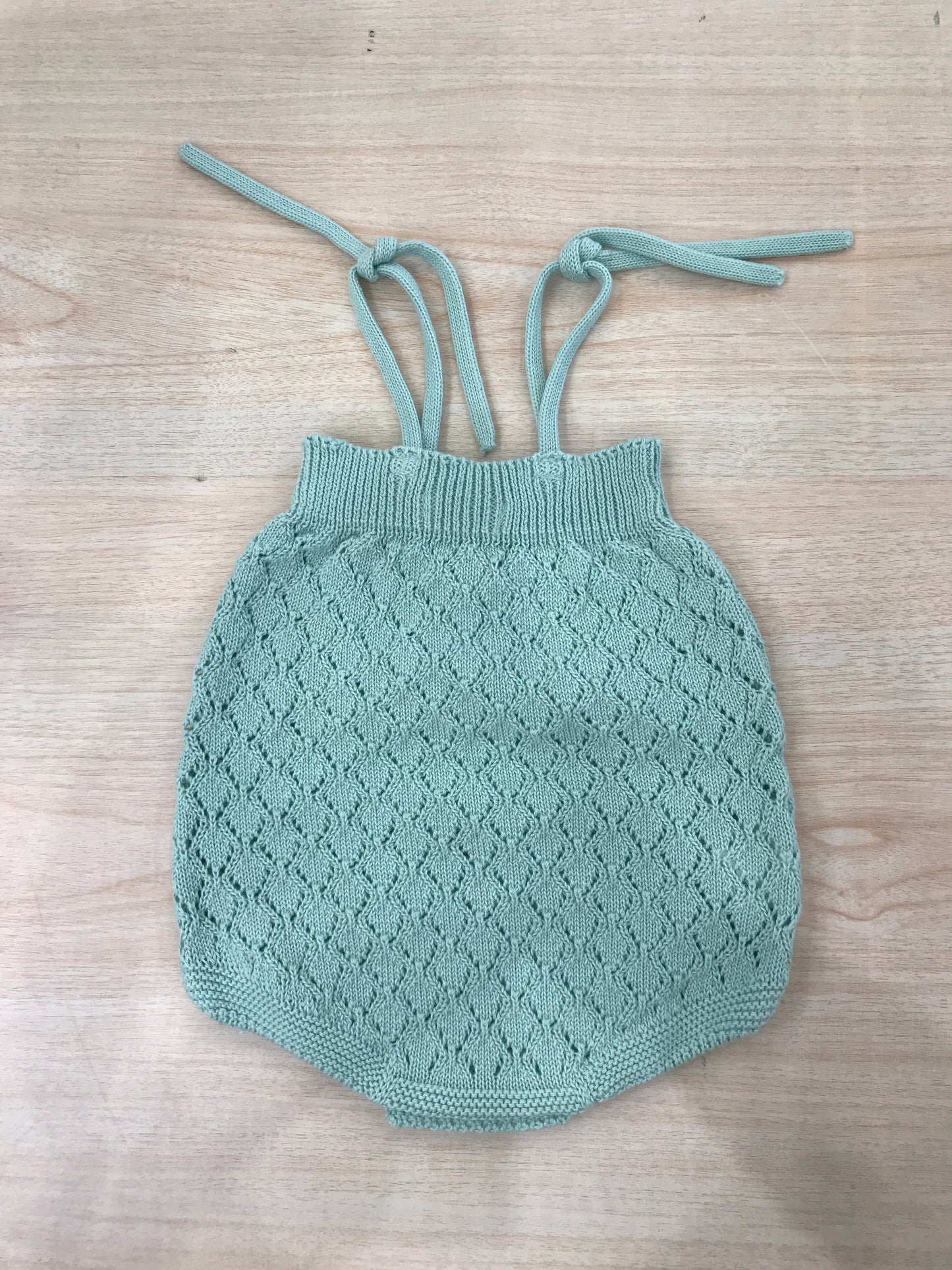 Salopette PCS in filo verde lavorata a maglia con fiocchetto sul davanti e bretelle regolabili