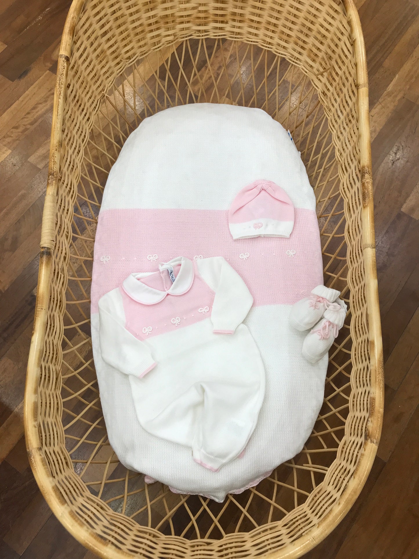 Coordinato nascita Bebè di Almy in filo bianco e rosa con delicati fiocchi bianchi e rosa ricamati su tutina coperta e cappello abbinate anche le babbucce