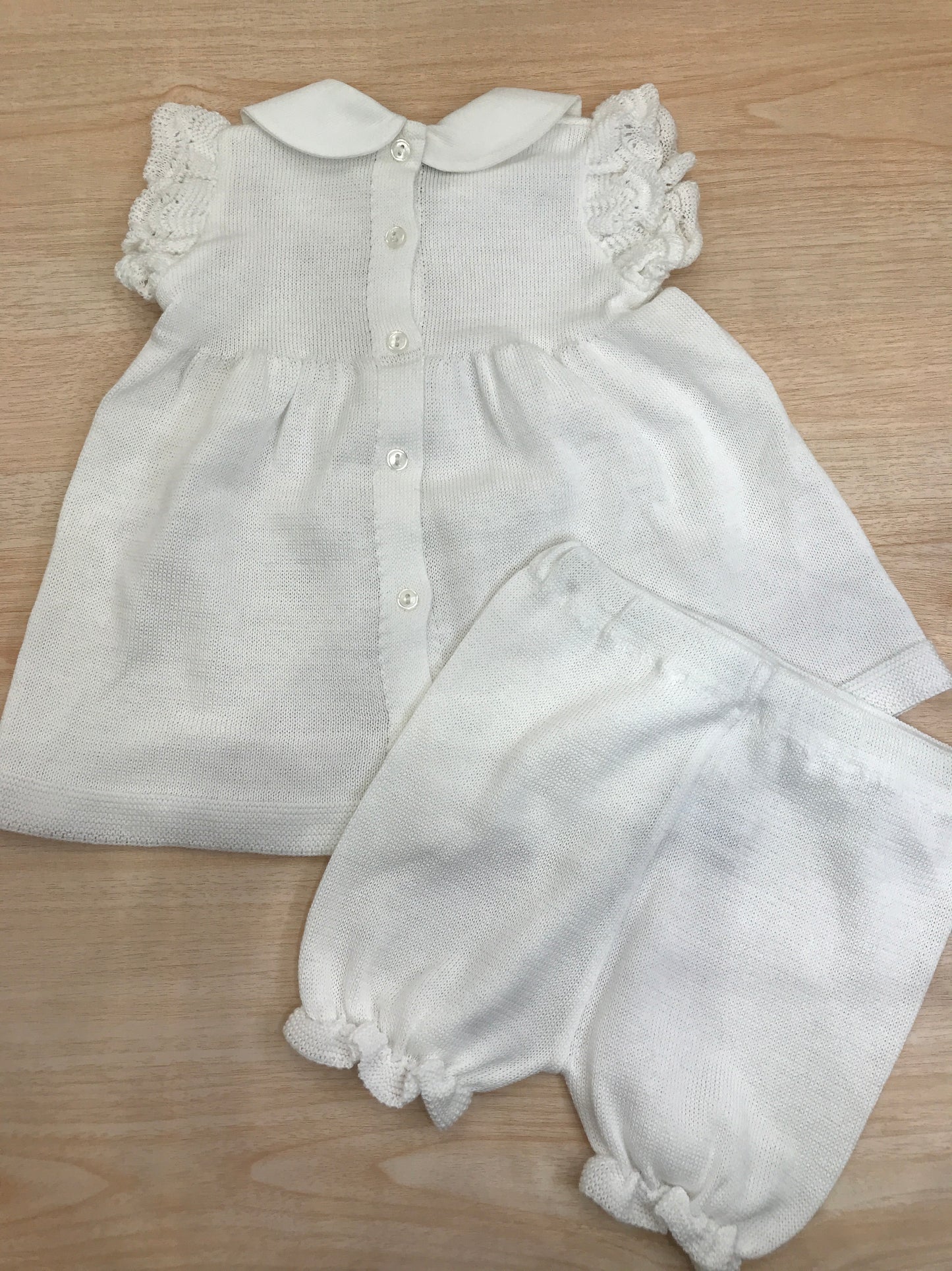 Completo Baby Lord in filo bianco due pezzi smanicato con rusche collo tondo roselline ricamate sul petto e fiocchetto rosa