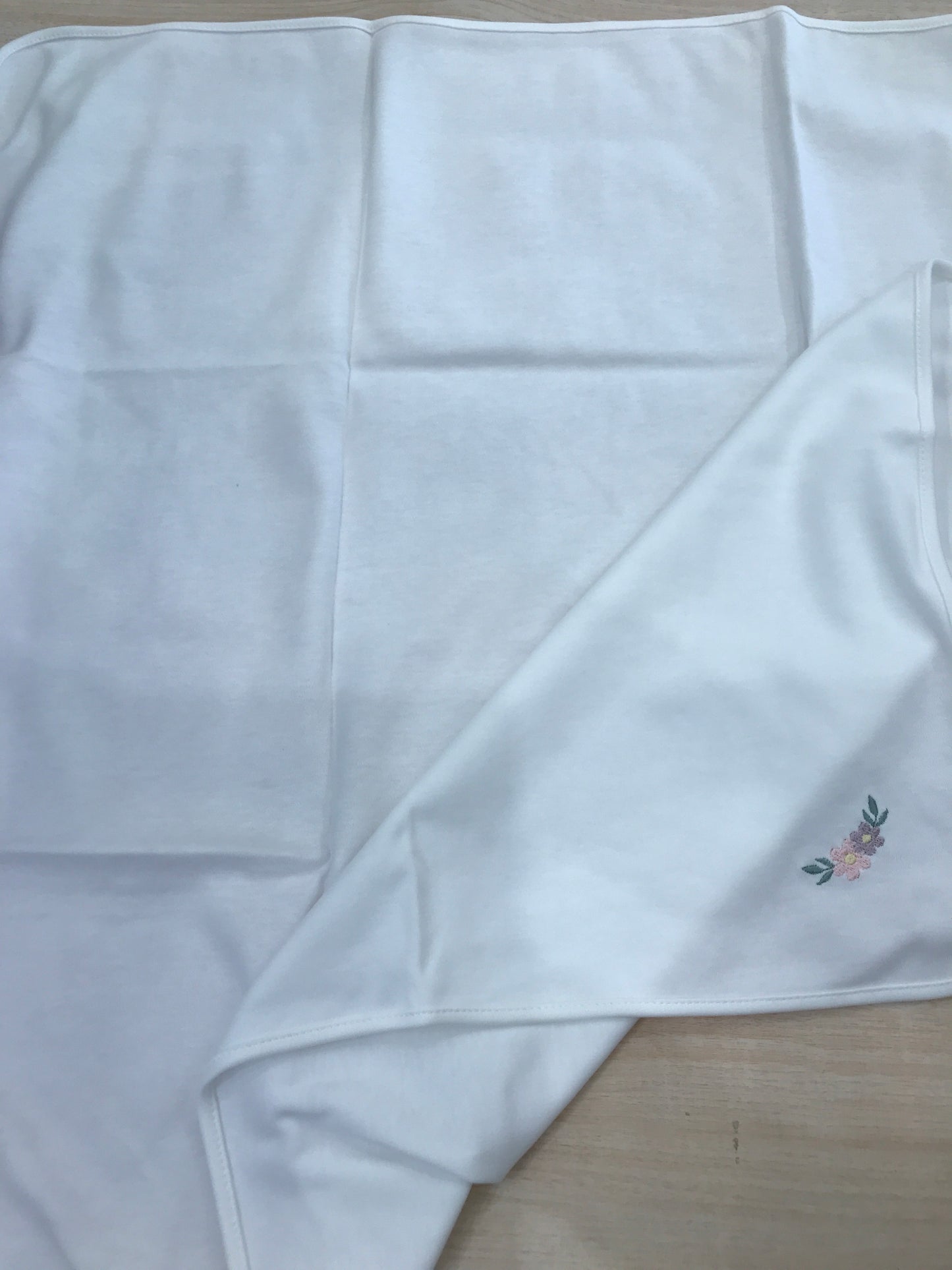 Mussola Baby Gi in cotone panna con fiore camelia ricamato