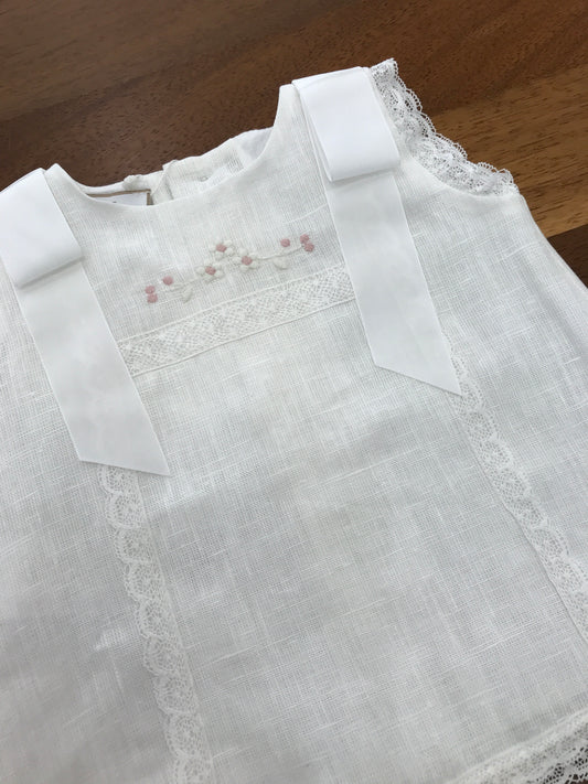 Completo Paz Rodriguez in lino bianco con fiocchi sulle spalle con merletto con fiori ricamati sul davanti con culotte e cuffia abbinata