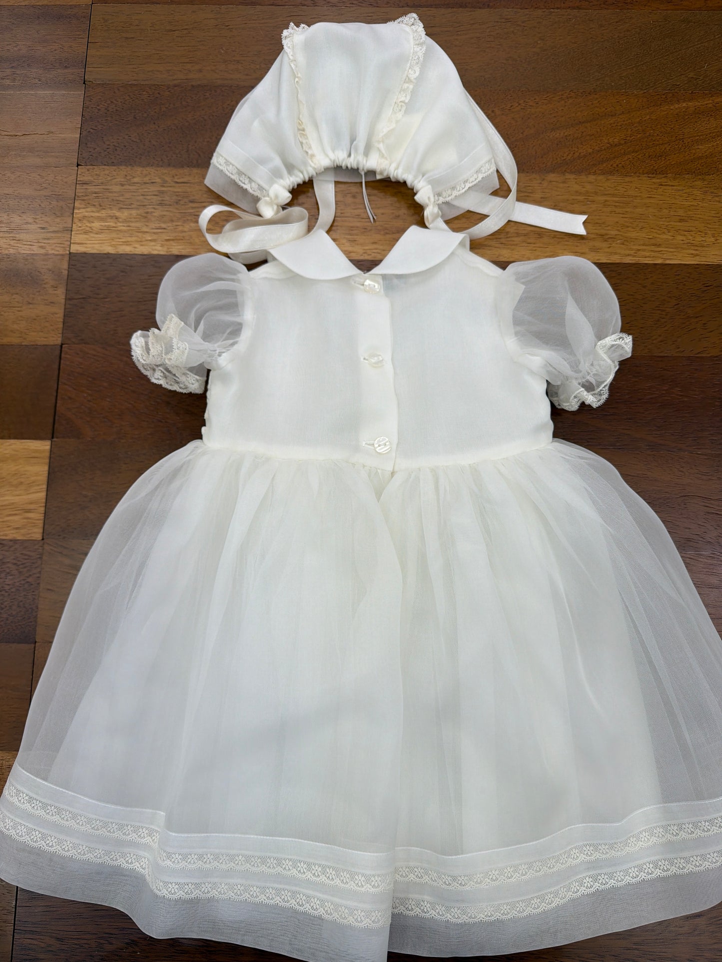 Abito Piccola Giuggiola in organza in seta panna manica corta a sbuffo corpetto lavorato in pizzo con fiori ricamati a mano sul gonnellone pizzo ricamato stessa lavorazione sulla cuffietta