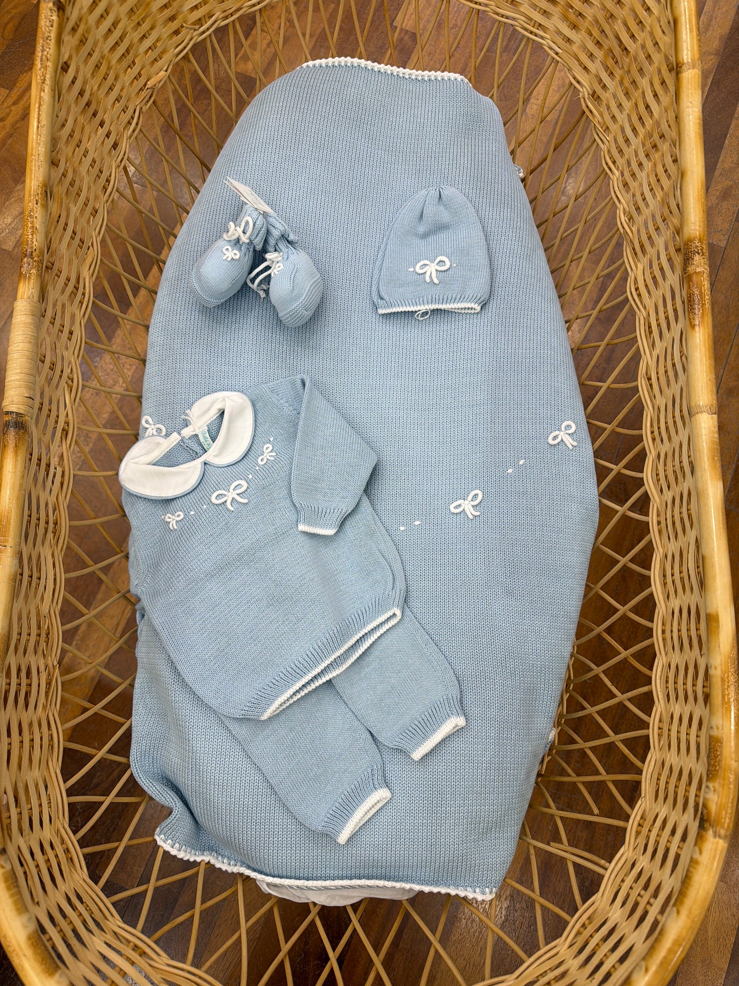 Coordinato nascita Bebè di Almy in filo celeste con piccoli fiocchi bianchi ricamati a mano tutina due pezzi cappello e babbucce con la stessa decorazione