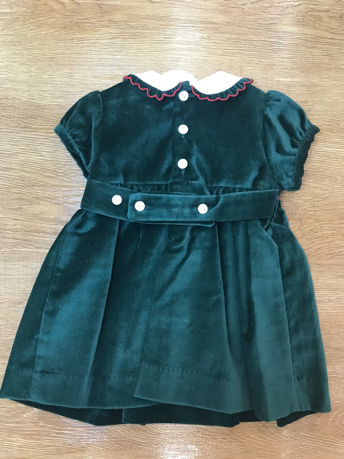 Abito Les Enfants de Gisele in velluto verde scuro con corpetto lavorato da punto smock e piccole roselline