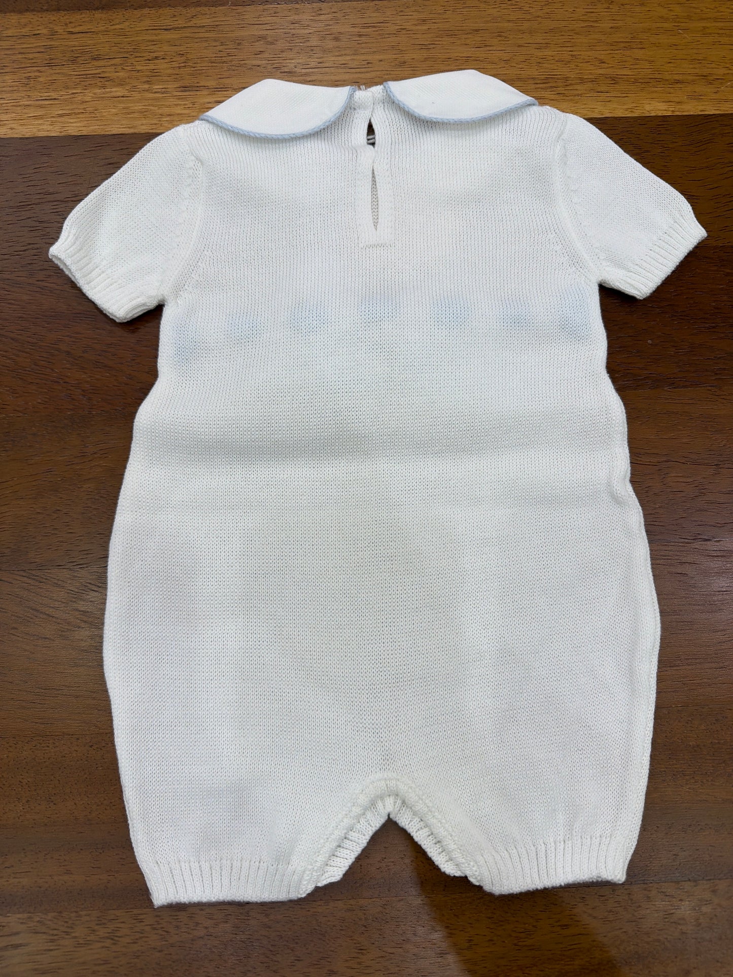 Pagliaccetto Baby Lord in filo bianco con passanastro celeste e fiocco centrale sul davanti mezza manica collo tondo bianco