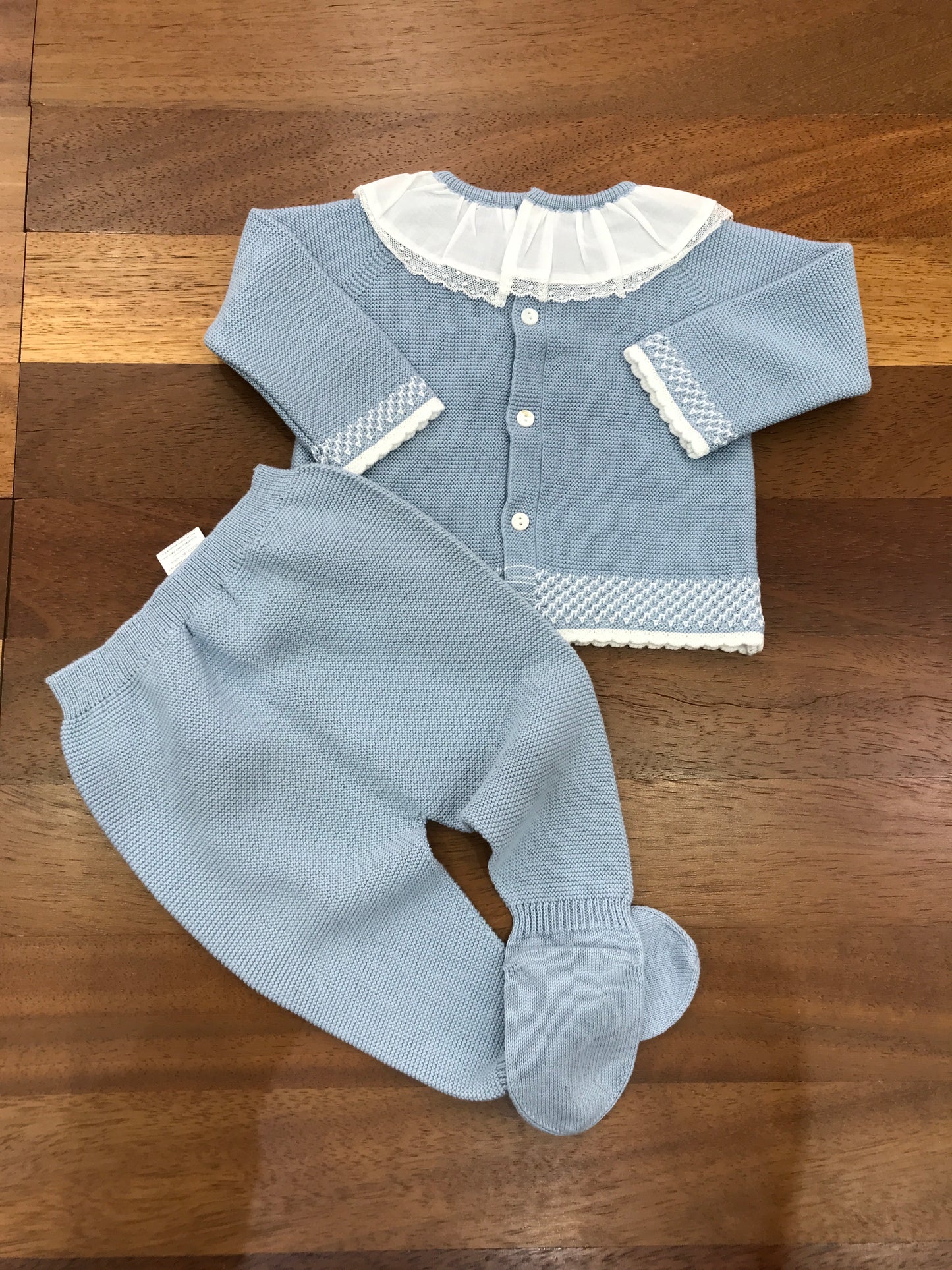 Tutina Martin Aranda in filo celeste polvere due pezzi con piedini manica lunga dettagli in bianco collo con rusche bianca