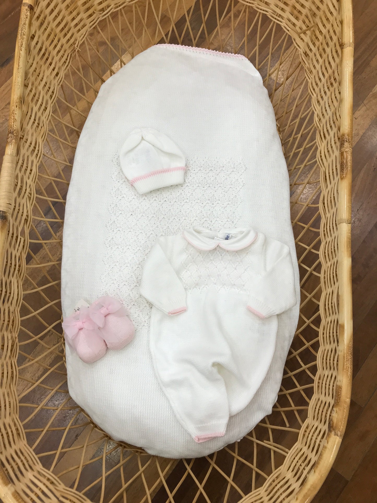 Coordinato nascita Bebè di Almy in filo bianco con punto smock rosa ricamato su tutina e coperta cappellino abbinato babbucce rosa con fiocco sul davanti