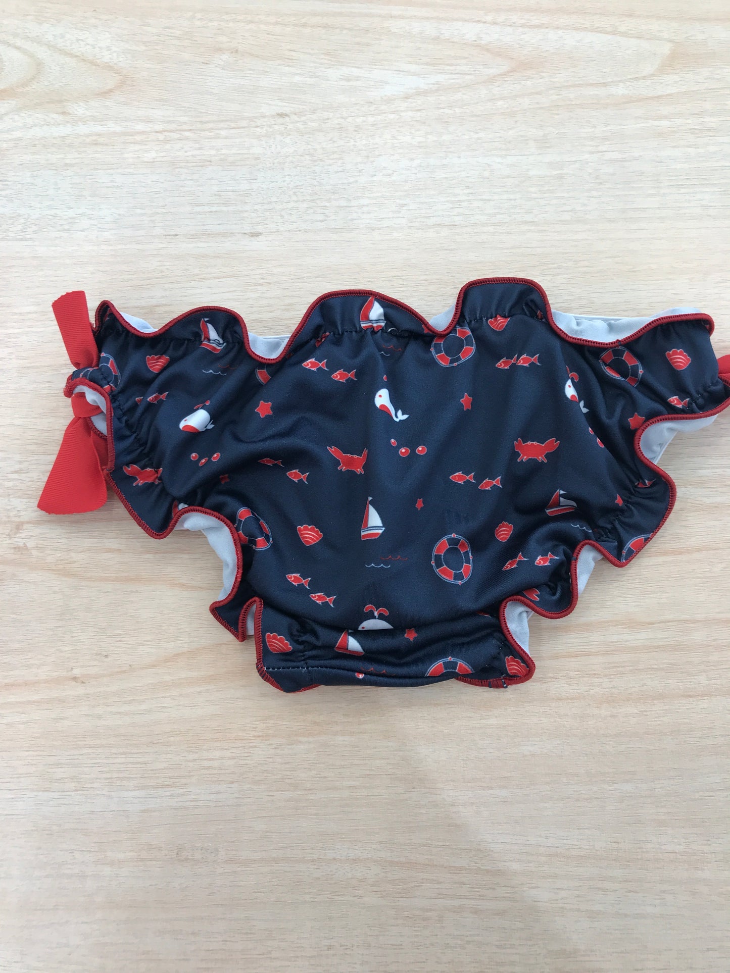 Costume Paz Rodriguez con rusche blu scuro con piccoli disegnini con fiocchetti rossi laterali