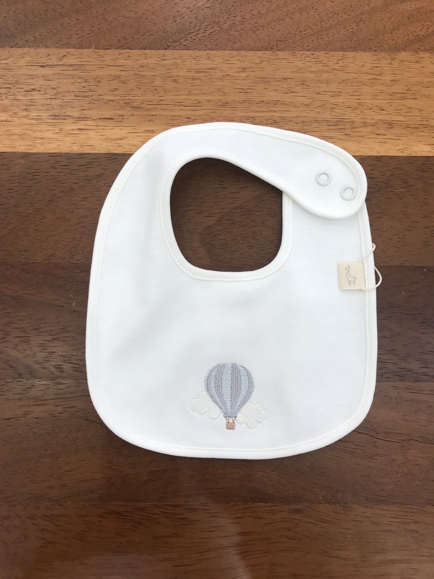 Bavetta Baby Gi in cotone bianca con mongolfiera ricamata sul davanti