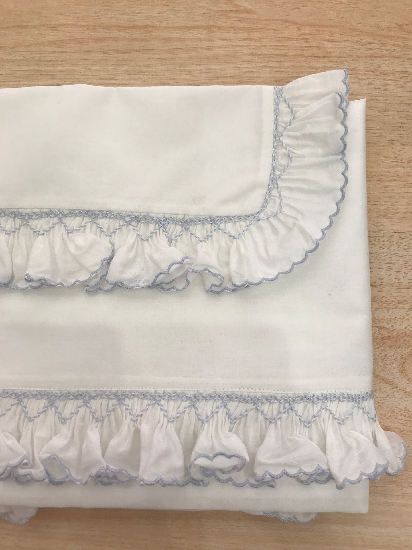 Lenzuolino Colibrì in cotone di battista bianco con rusche ai bordi e lavorazione di punto smock
