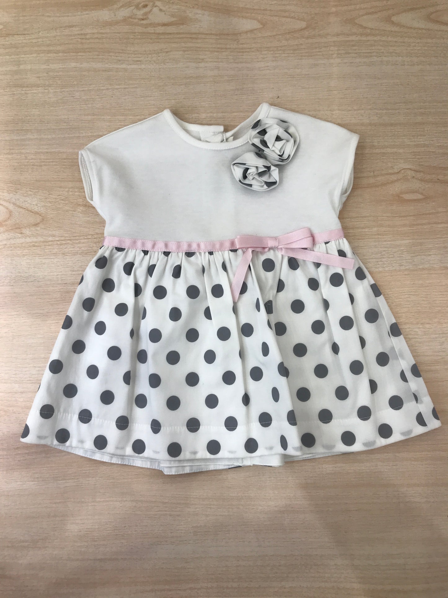 Abito Cielo Blu in cotone con gonna bianca con pois neri con fiori applicati lateralmente e fiocco rosa in vita con culotte abbinata