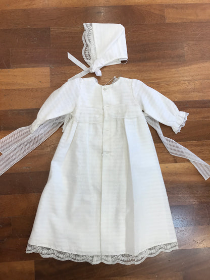 Abito lungo Paz Rodriguez in battista di cotone manica lunga con fiocchetti laterali pizzo e cuffietta coordinata