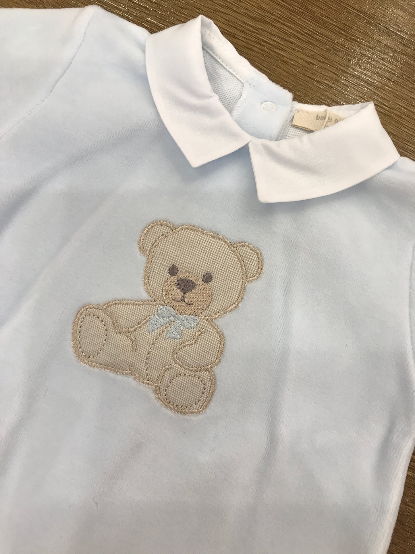Tutina Baby Gi in ciniglia celeste con orsetto applicato sul davanti con fiocchetto