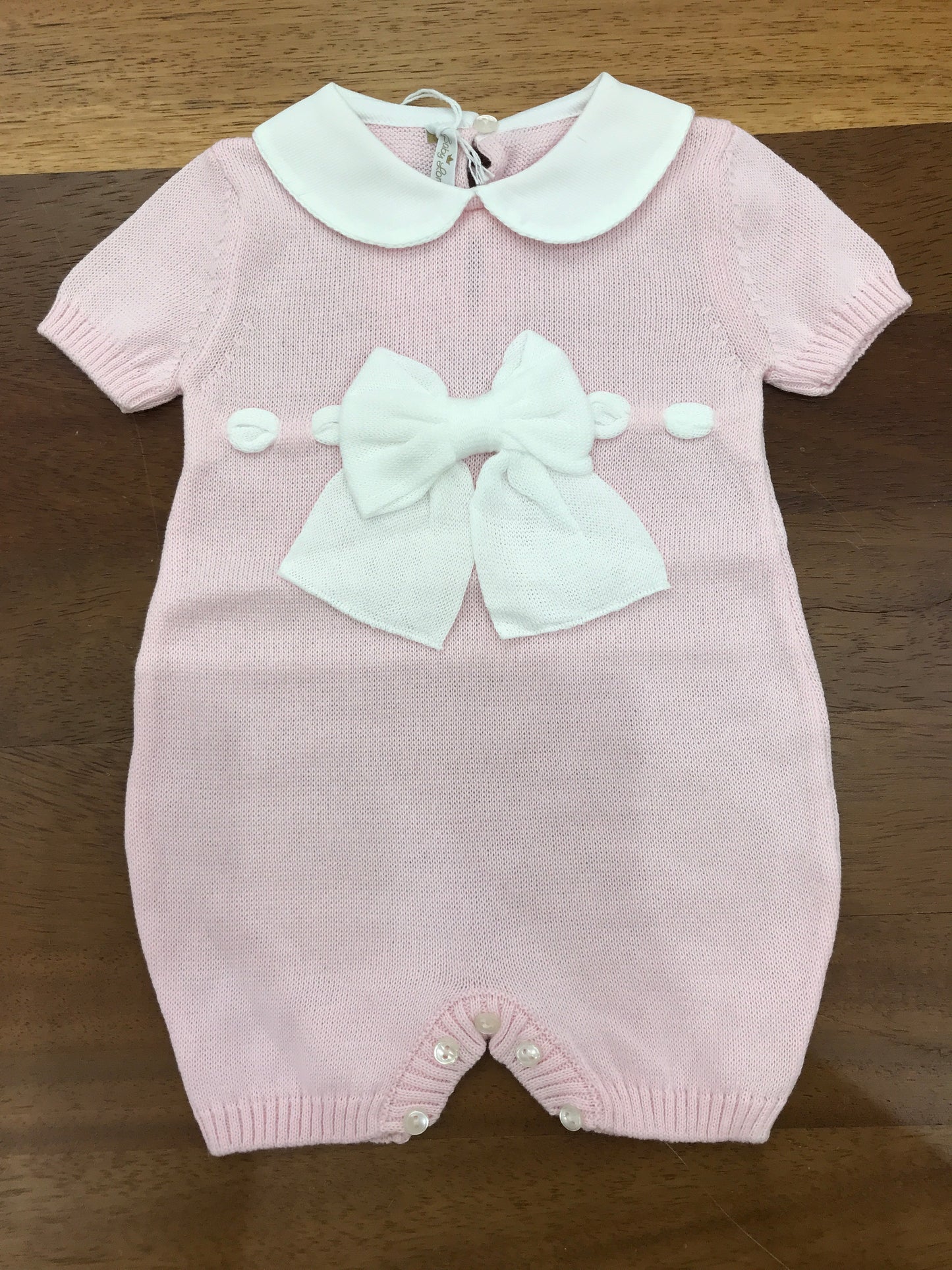 Pagliaccetto Baby Lord in filo mezza manica rosa collo tondo bianco con fiocchetto bianco sul davanti