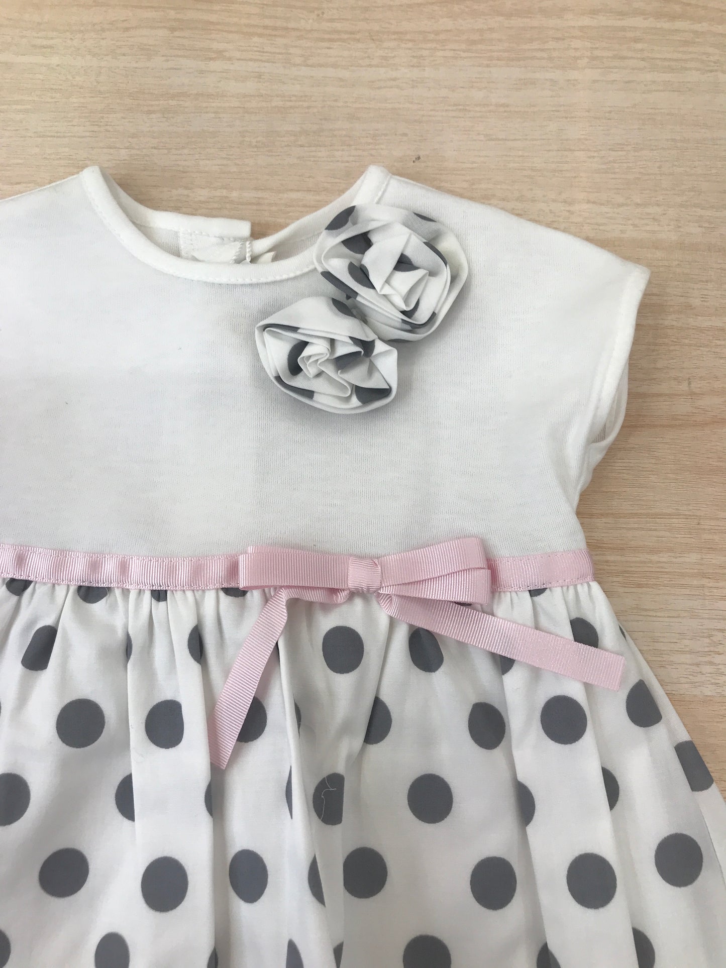 Abito Cielo Blu in cotone con gonna bianca con pois neri con fiori applicati lateralmente e fiocco rosa in vita con culotte abbinata