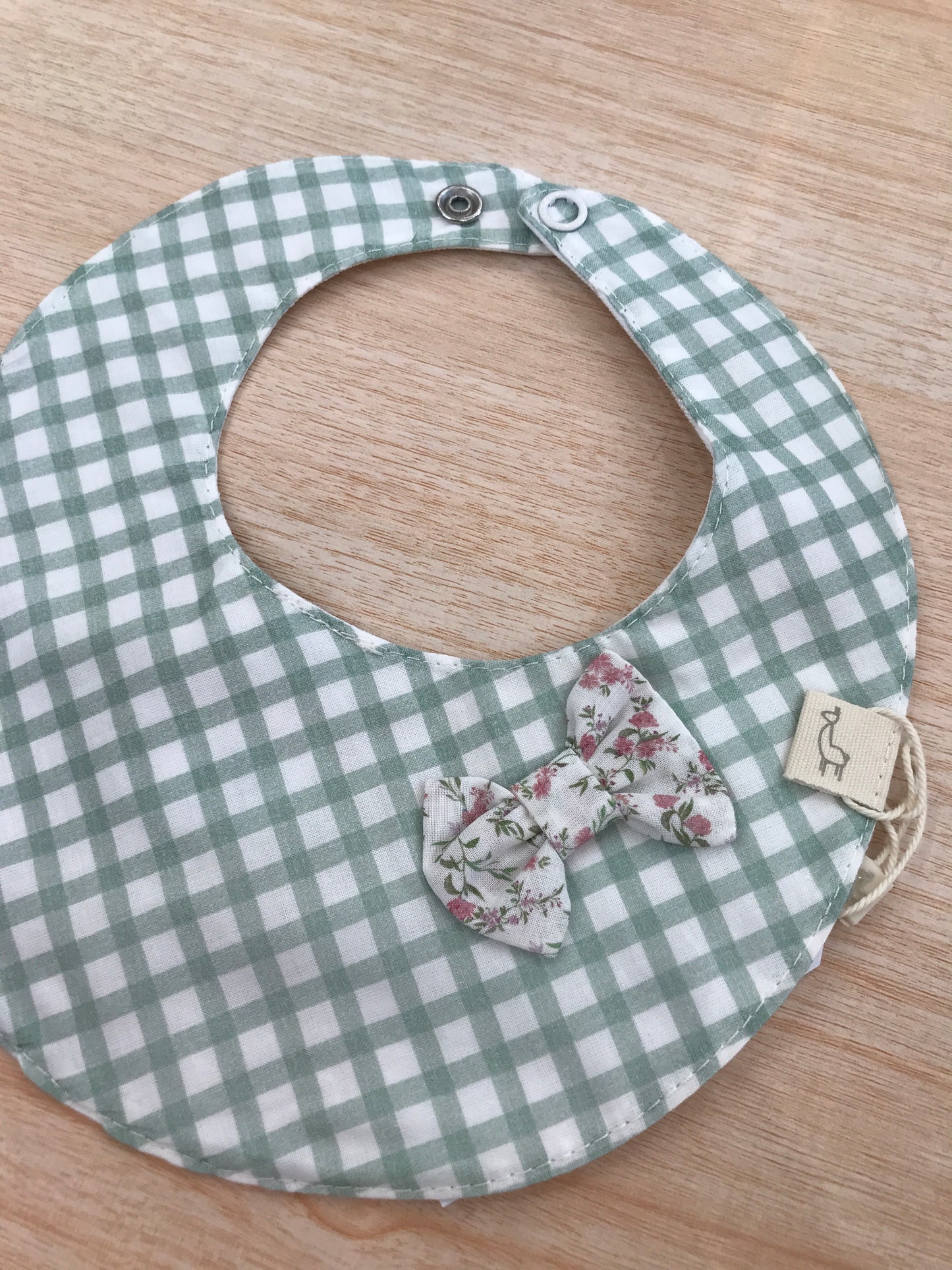 Bavaglino Baby gi in cotone dalla forma rotonda a quadretti bianchi e verdi con fiocchetto floreale