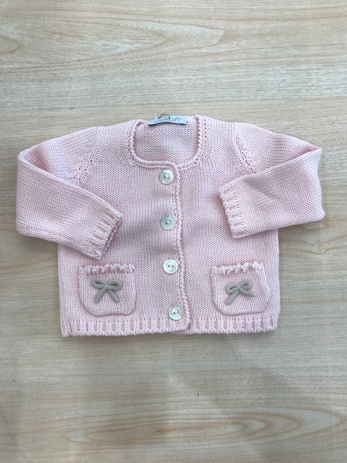 Cardigan Colibrì in filo rosa con bottoni sul davanti con tasche sul davanti e fiocchetti sulle tasche
