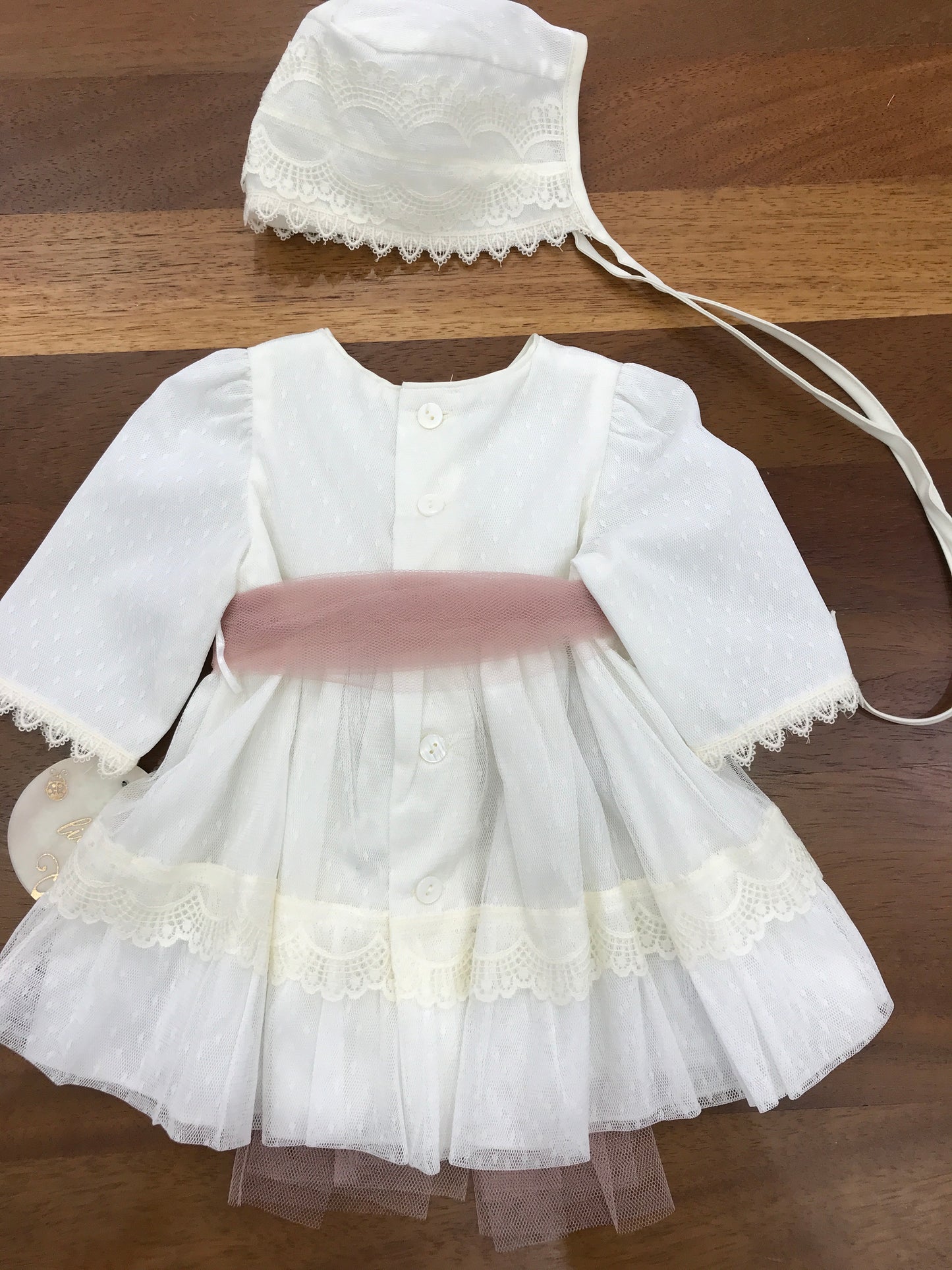 Abito Lilus manica lunga in cotone ricoperto di tulle lavorato senza collo con pizzo ai polsi e un applicazione sempre in pizzo sul davanti lo stesso pizzo viene richiamato sul gonnellone ed una cintura in tulle