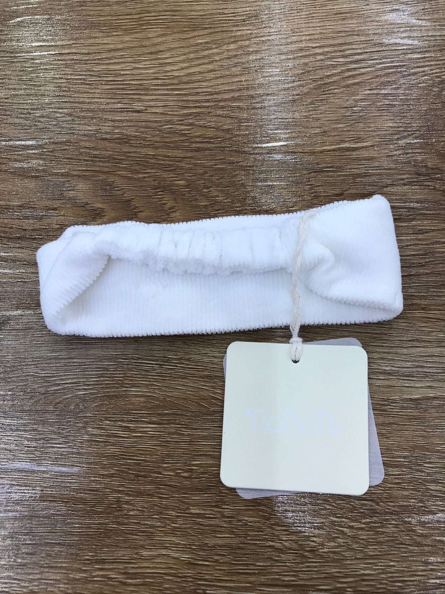 Fascia Nanan in ciniglia a costine bianca con elastico sul retro e fiocchetti sul davanti