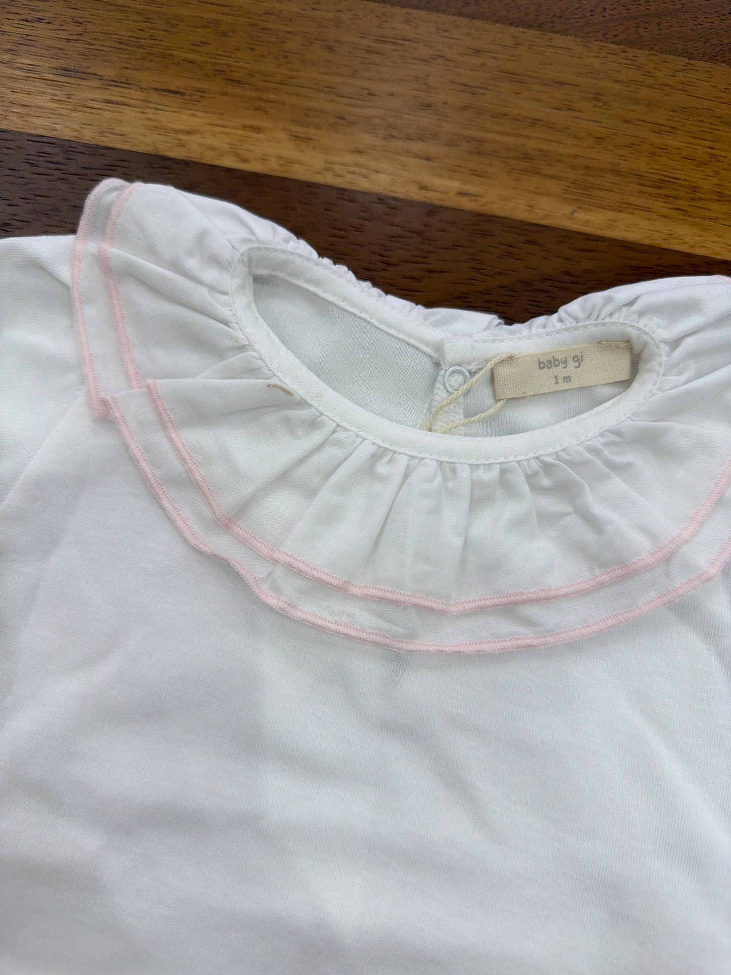 Body Baby Gi in cotone bianco con mezza manica con collo con rusche dal profilo rosa