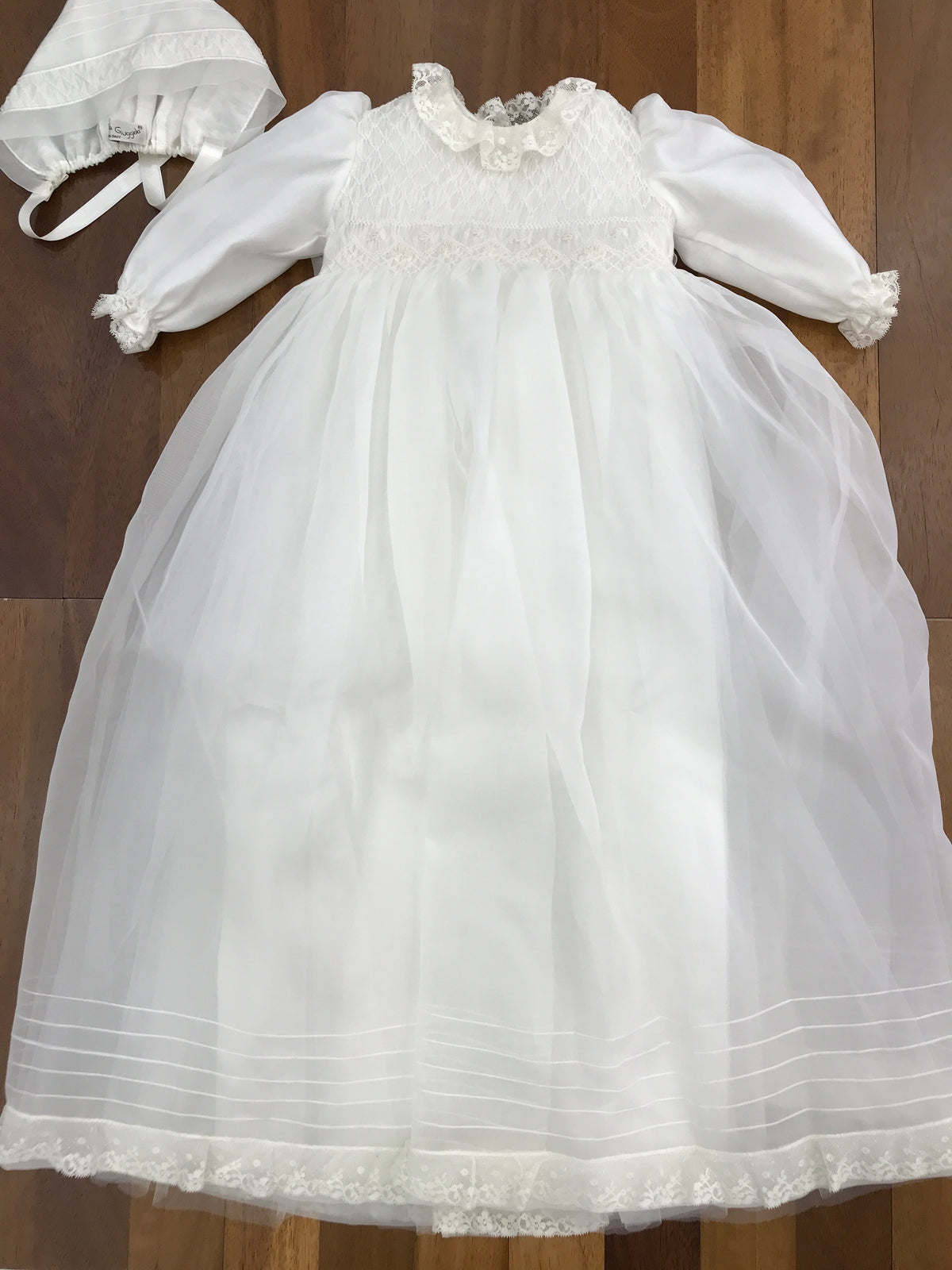 Abito lungo Piccola Giuggiola in organza in seta con gonna lavorata da pizzo corpetto manica lunga con lavorazione di punto smock e roselline ricamate a mano con cuffia coordinata e con punto smock