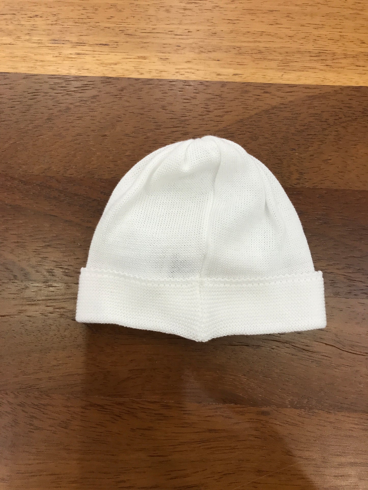 Cappello Baby Lord in filo bianco con risvolto con fiocco celeste applicato sul davanti