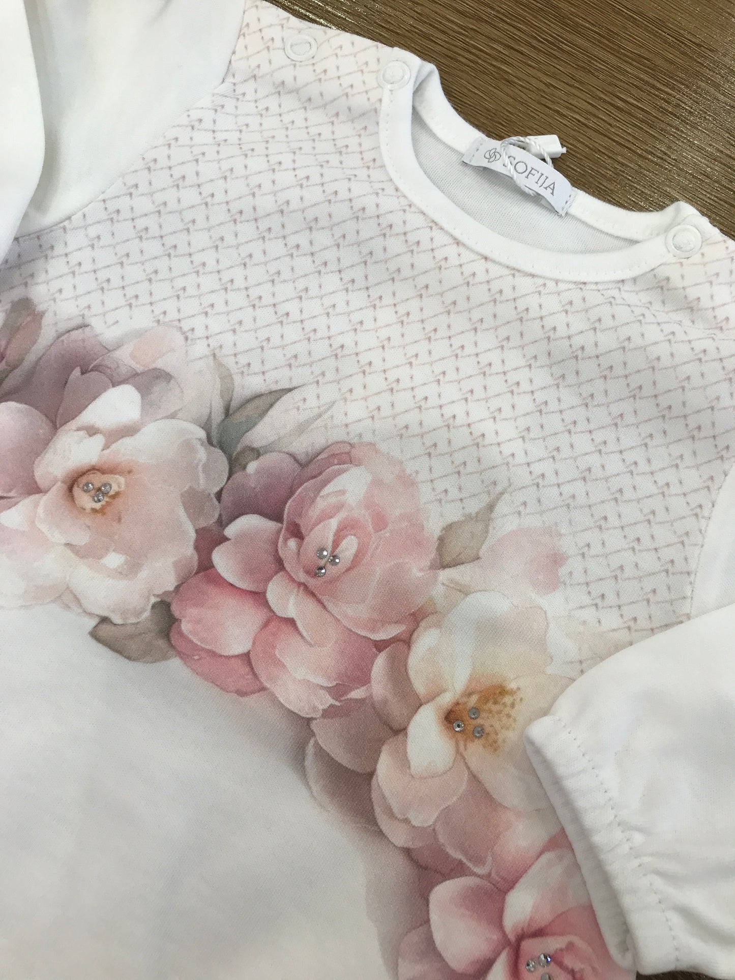 Pagliaccetto Sofija in caldo cotone manica lunga con fiori in rosa sul davanti