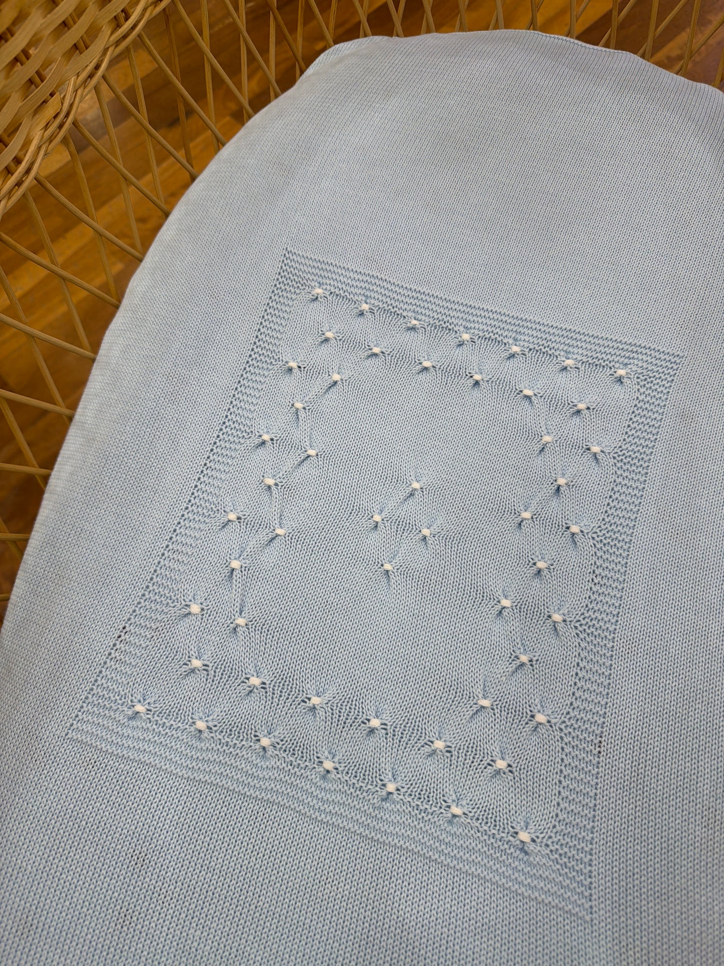 Coperta Baby Lord in filo celeste con lavorazione di punto smock bianco sul davanti