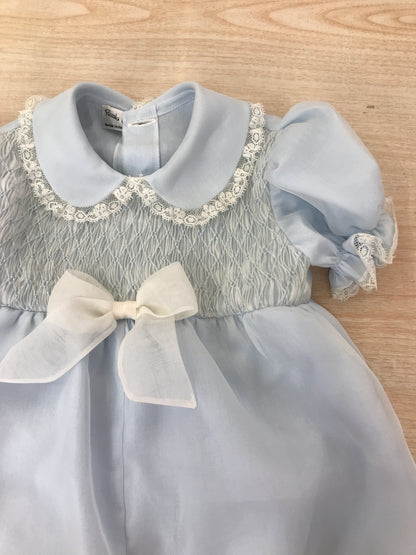 Pagliaccetto Piccola Giuggiola in organza in seta celeste manica a sbuffo con applicazone di valancienne corpetto rifinito da punto smock con fiocco centrale