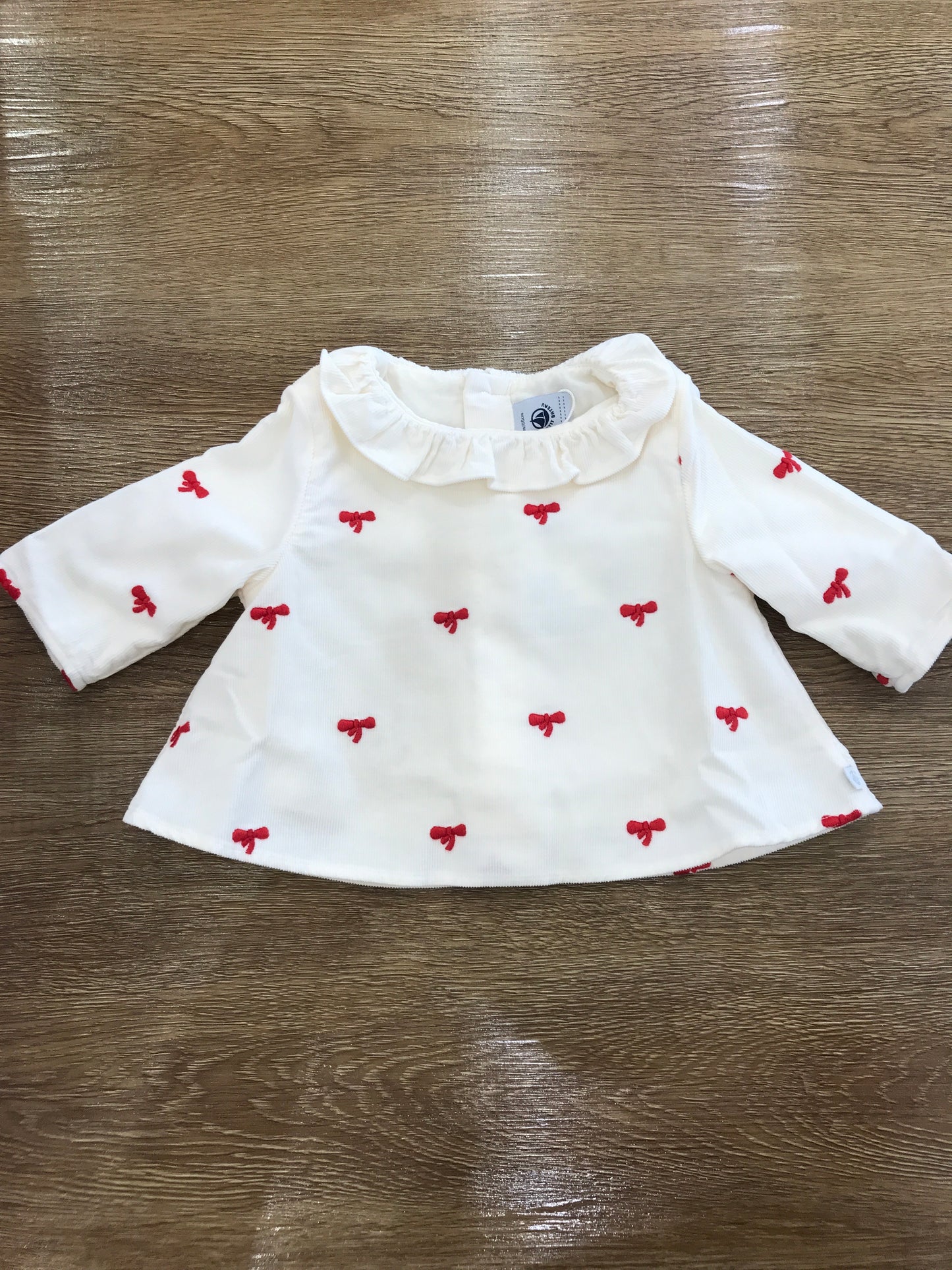 Maglietta Petit Bateau a costine con colletto con rusche con piccoli fiocchetti rossi ricamati