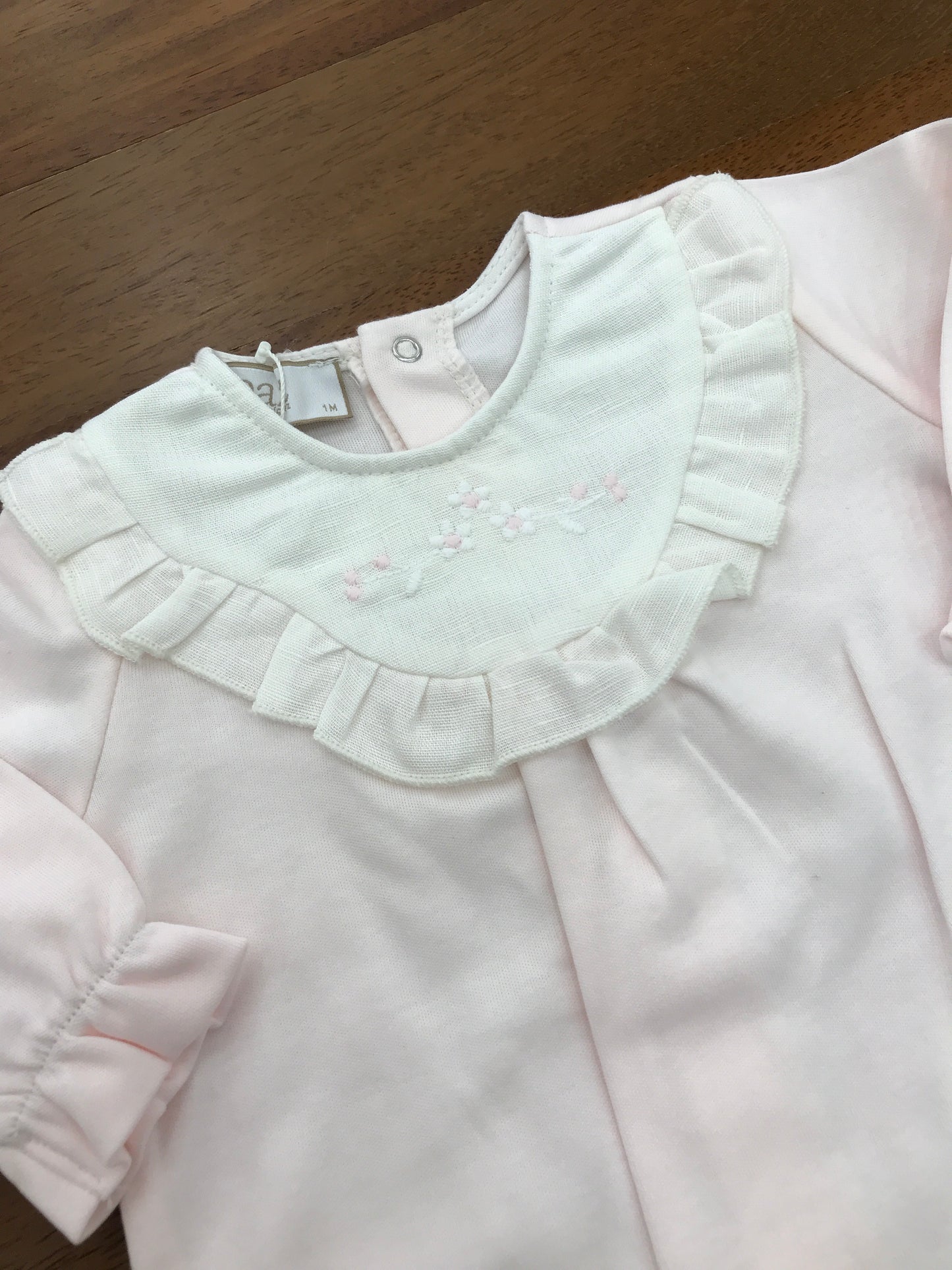 Tutina Paz Rodriguez in cotone rosa manica lunga con piedini collo in lino bianco con rusche con fiori bianchi e rosa