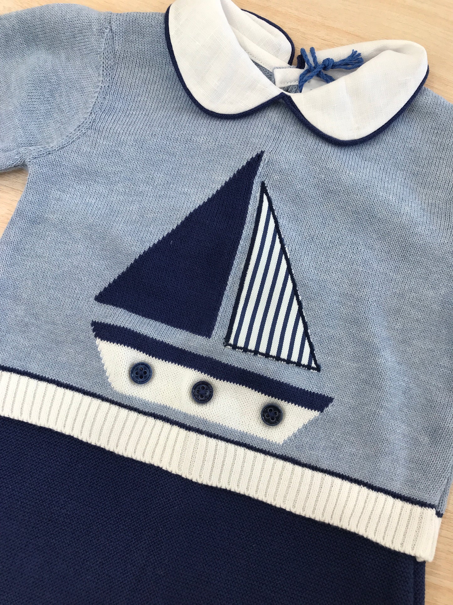 Tutina Colori Chiari in filo manica lunga gamba lunga dal tono blu scuro e celeste con rifiniture in bianco e barca a vela ricamata sul davanti