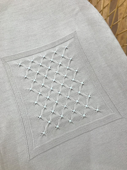 Coperta Baby Lord in lana color sabbia con punto smock celeste ricamato al centro di un riquadro centrale