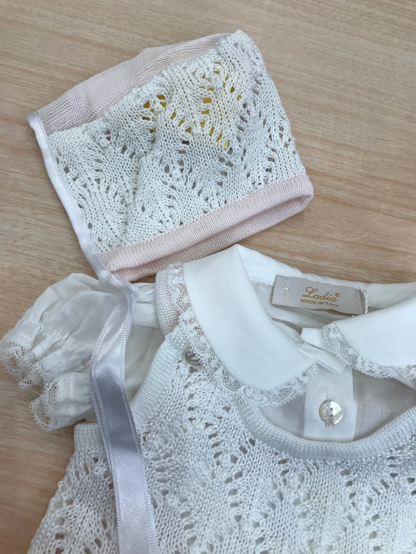 Pagliaccetto Ladia in filo traforato in rosa e bianco con camicina abbinata a sbuffo e cuffietta bianca e rosa traforata con laccio