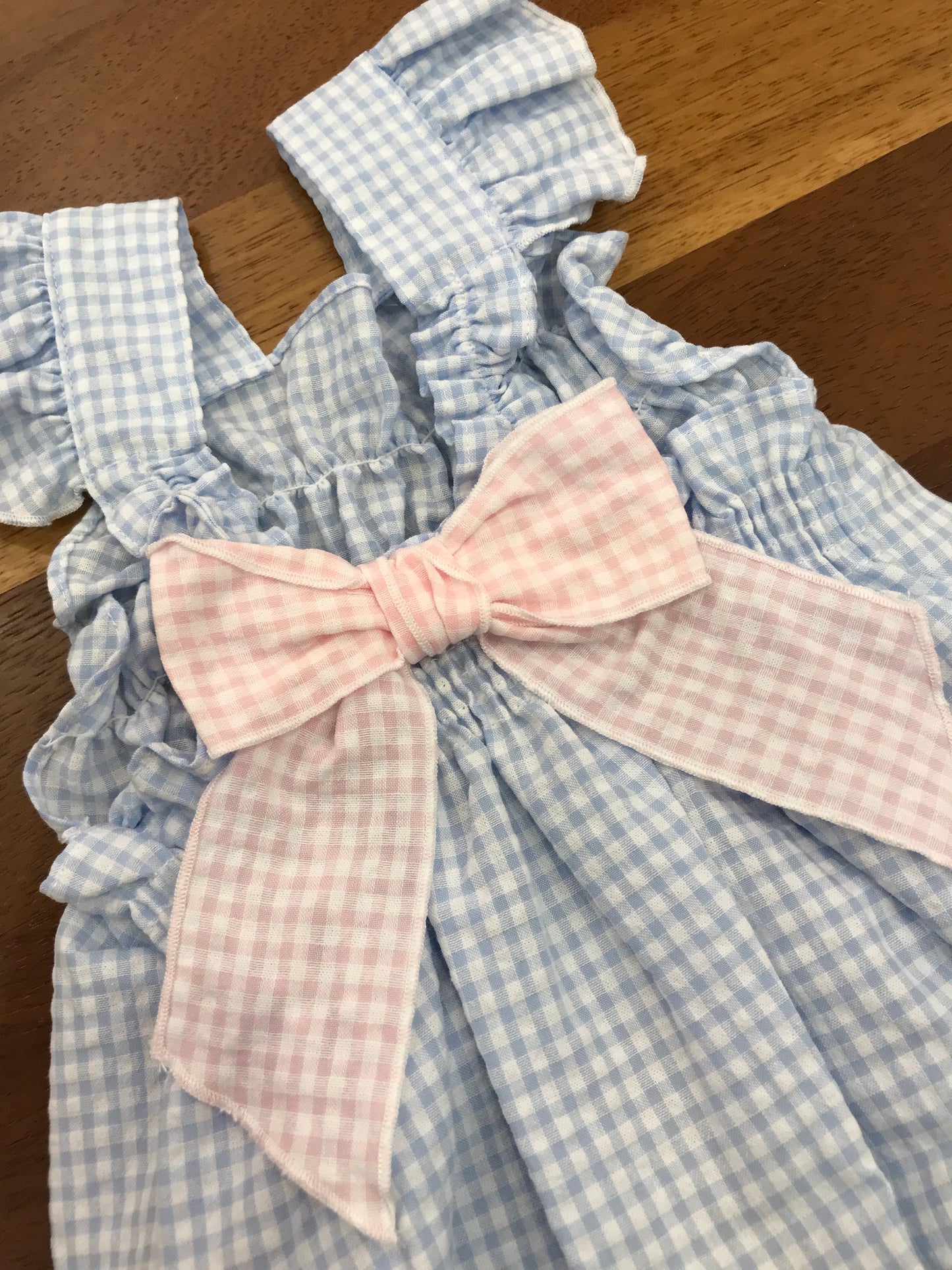 Pagliaccetto Baby Gi in cotone fantasia a quadretti con spalline con rusche con fiocco sul retro