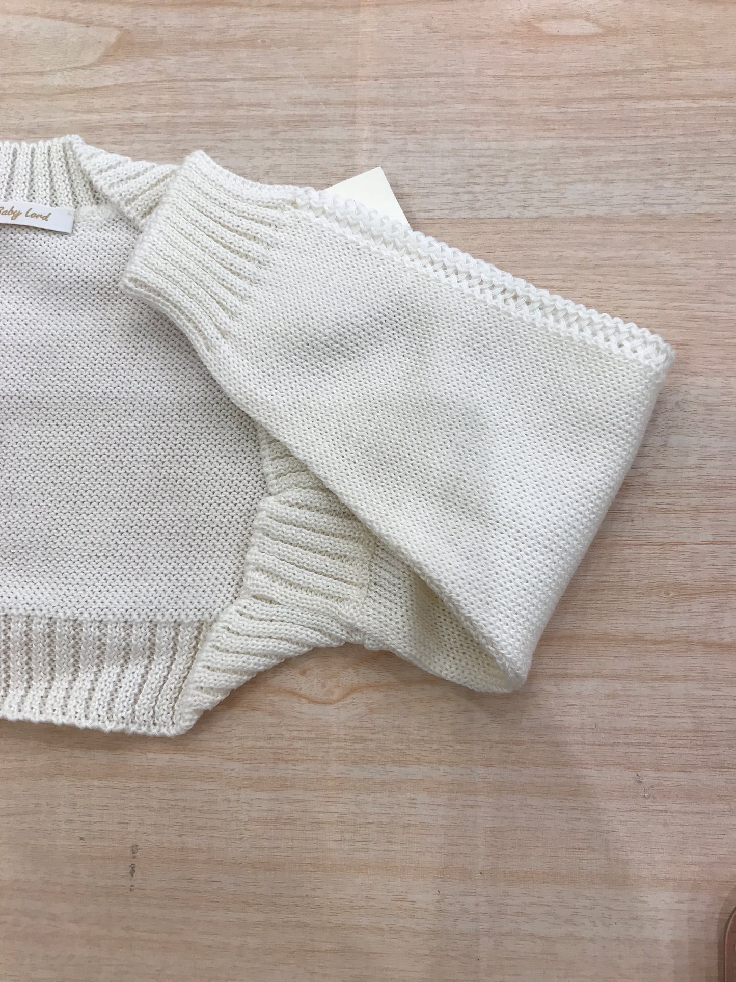 Cardigan Baby Lord in filo panna aperto sul davanti