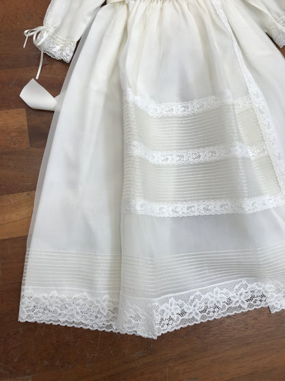 Abito lungo Belan in battista di cotone con tulle e pizzo con pieghe lavorato sul davanti manica lunga con cuffietta coordinata