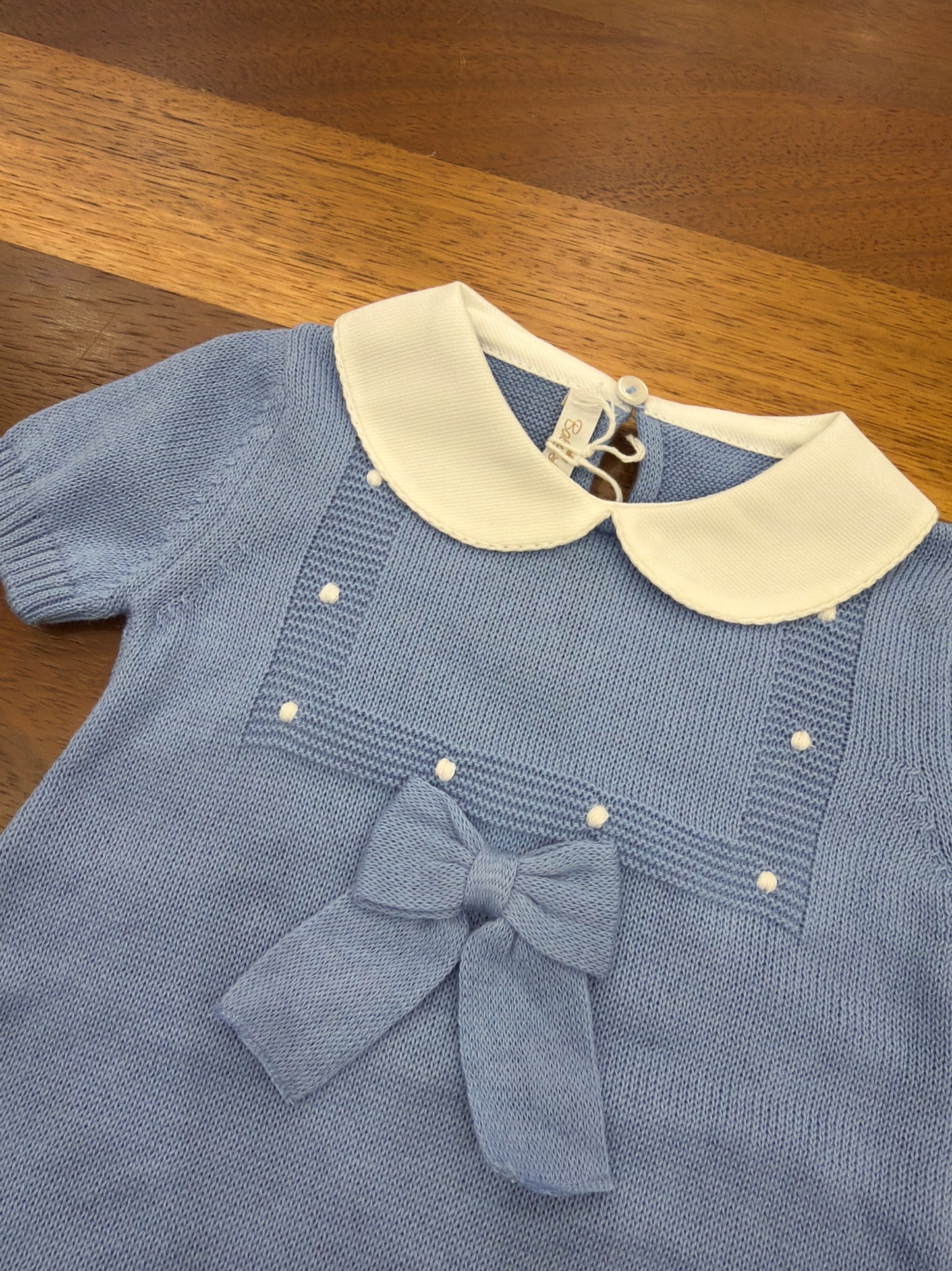 Pagliaccetto Baby Lord in filo celeste mezza manica collo tondo bianco riquadro con lavoro a maglia con pois bianchi e fiocco