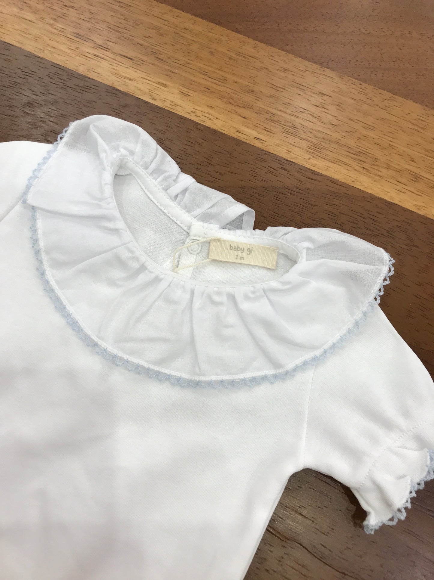 Body Baby Gi in cotone mezza manica con rusche collo con rusche rifinita in celeste