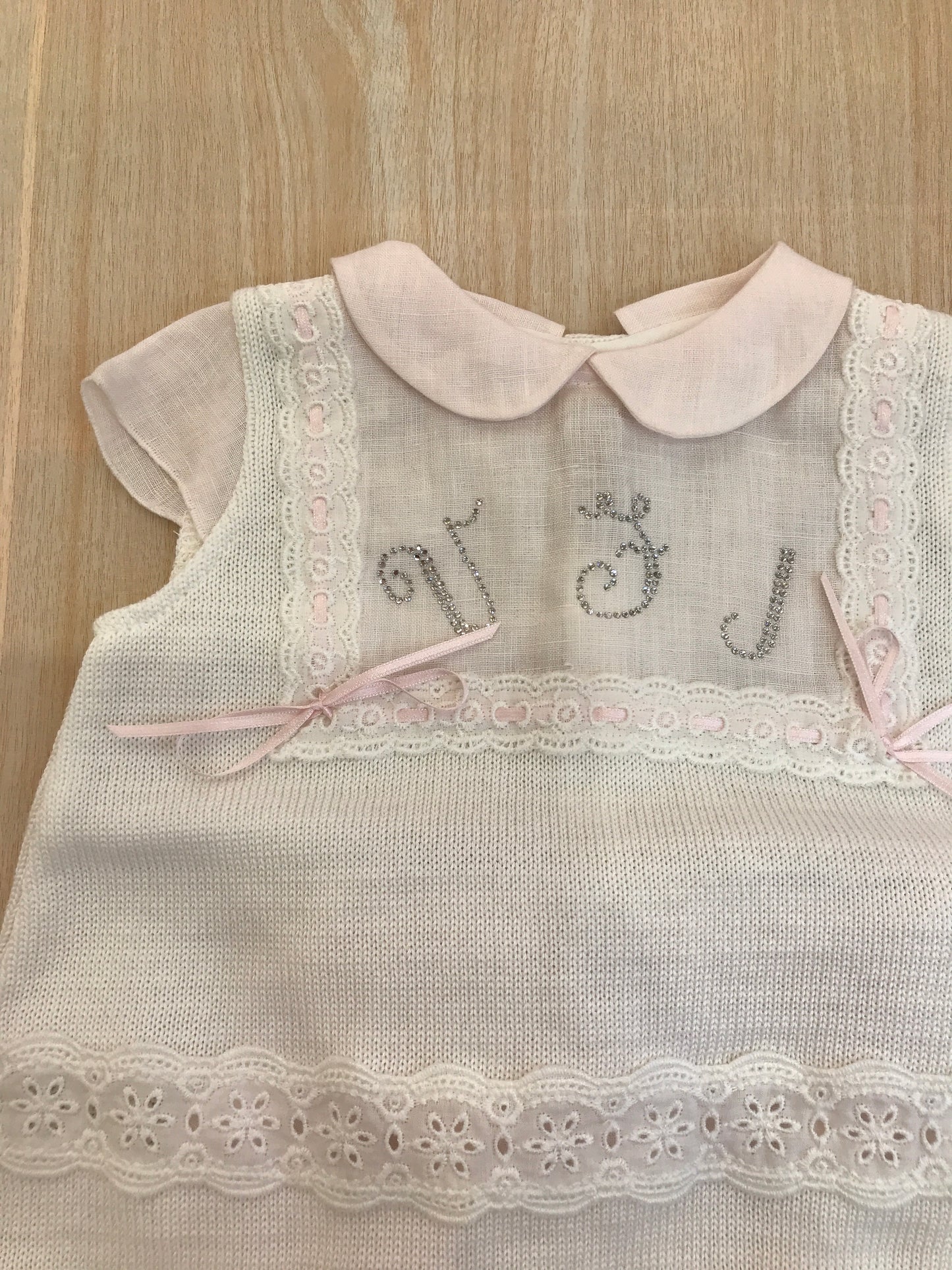 Completo Ladia in filo con rifiniture in lino e ricami in rosa e bianco con piccoli fiocchetti