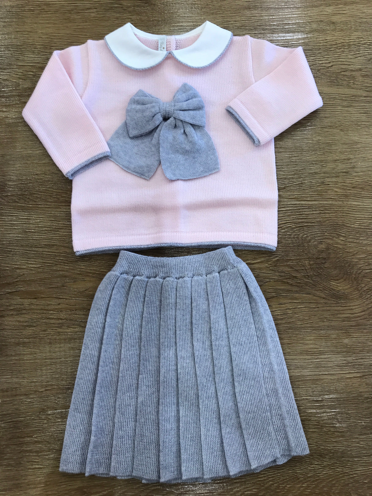 Completo Baby Lord in lana due pezzi rosa e grigio con fiocco centrale e gonna plissettata