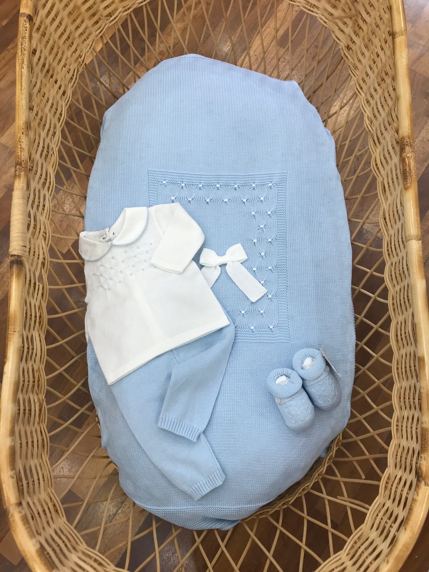 Coordinato nascita Baby Lord in filo celeste coperta con punto smock bianco con fiocco tutina due pezzi bianca e celeste con punto smock babbucce celesti